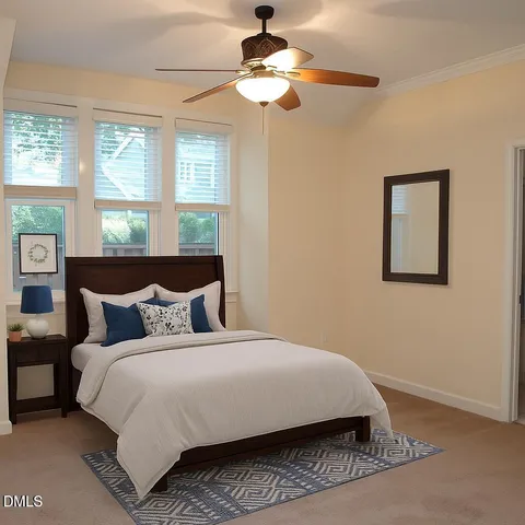 a bedroom with a bed ceiling fan and a window