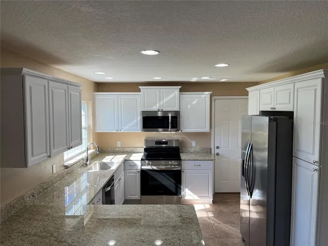 a kitchen with a refrigerator and a stove top oven