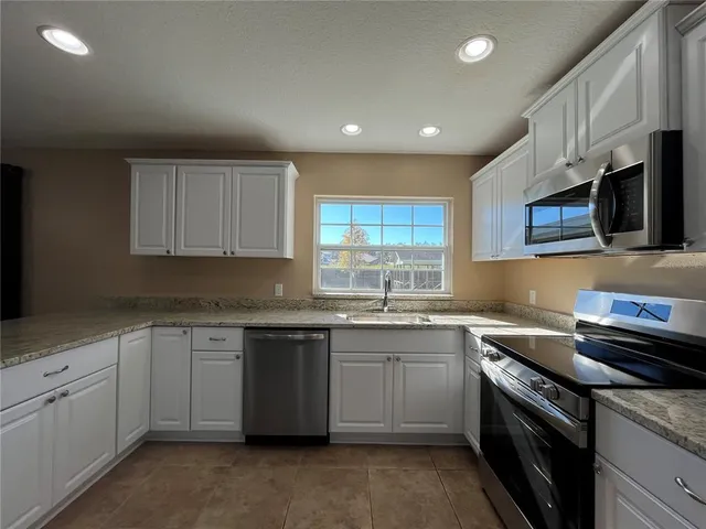 a kitchen that has a sink and a stove top oven
