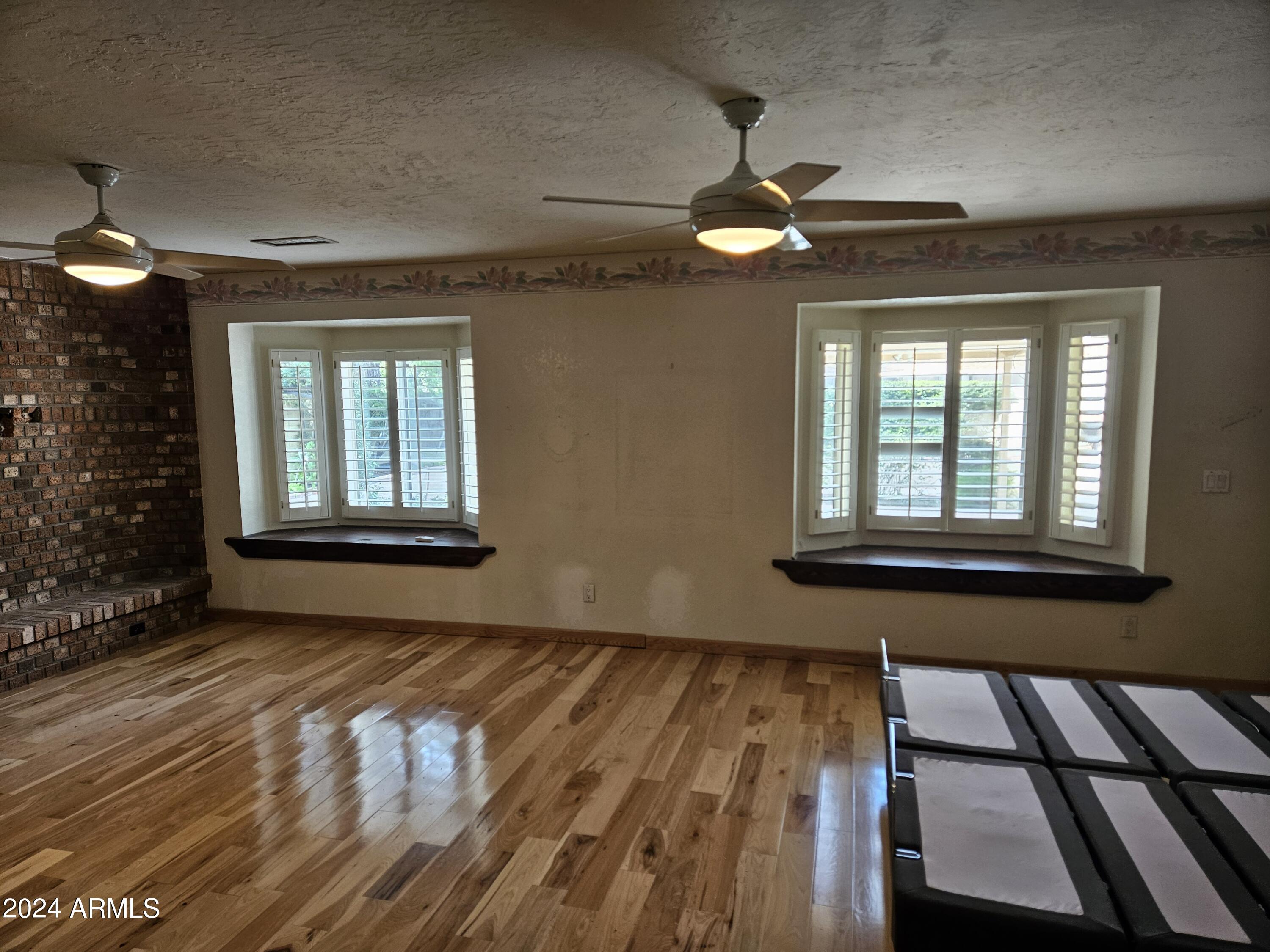 948 East Grandview Road Phoenix, AZ 85022 - Photo 19 of 43 a view of an empty room with a window and wooden floor