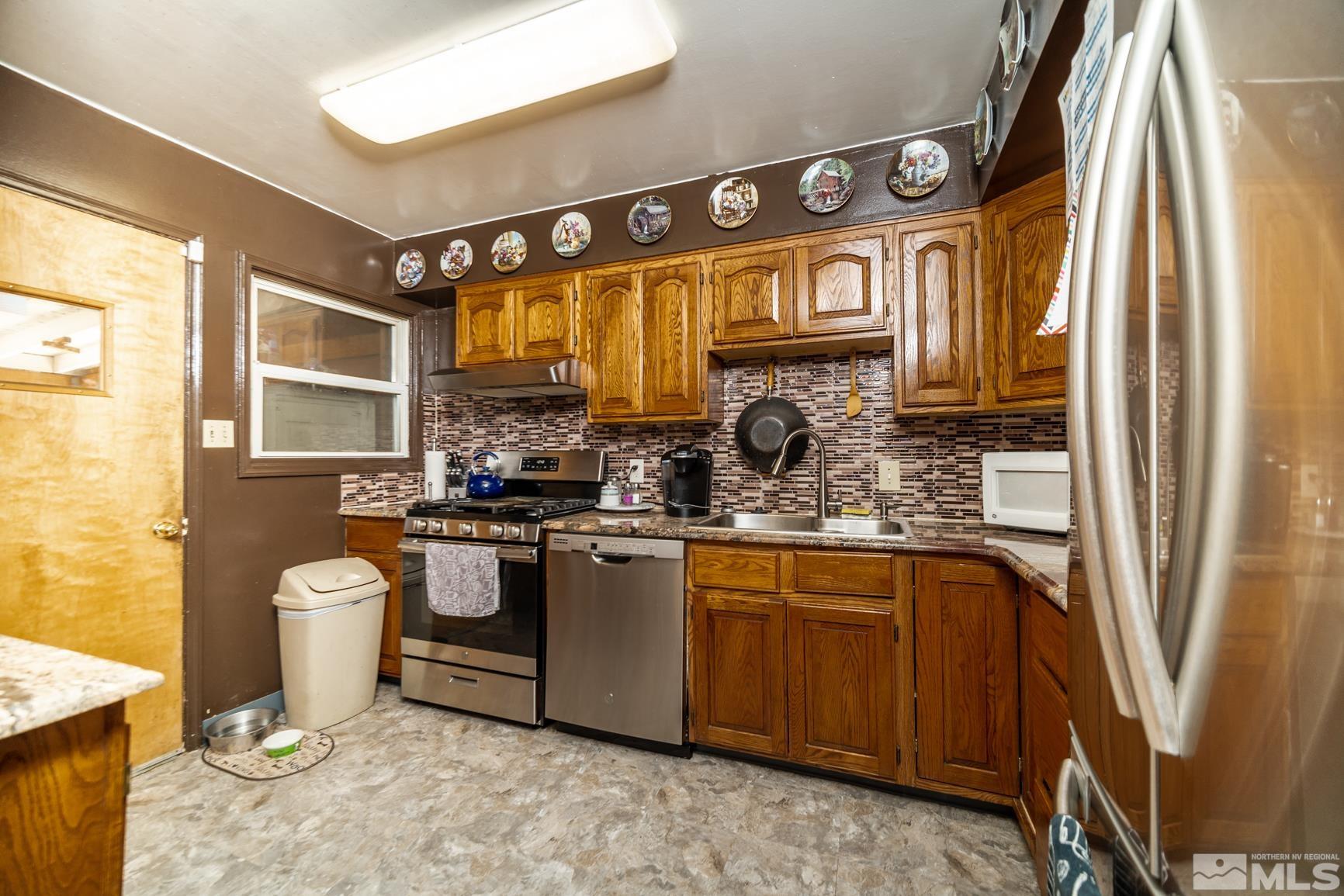 780 Stoker Avenue Reno, NV 89503 - Photo 7 of 25 a kitchen with stainless steel appliances granite countertop a sink stove and refrigerator