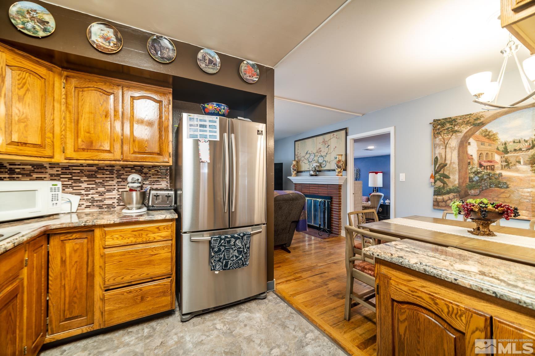 780 Stoker Avenue Reno, NV 89503 - Photo 8 of 25 a kitchen with stainless steel appliances granite countertop a refrigerator and a stove top oven