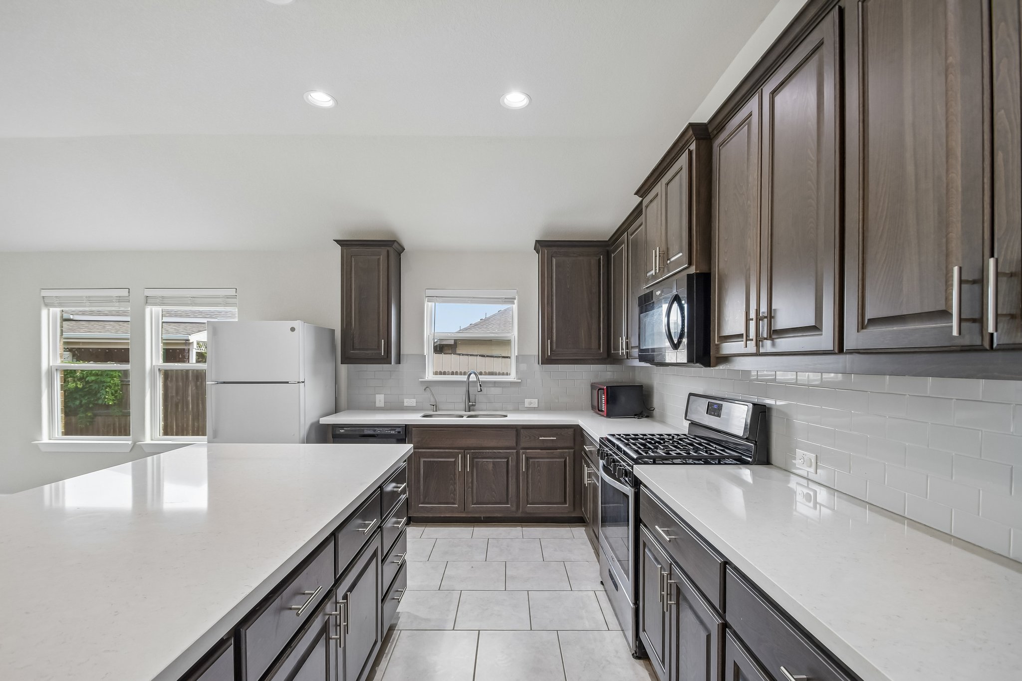 Gleaming stone countertops and classic cabinetry anchor this well-appointed kitchen.