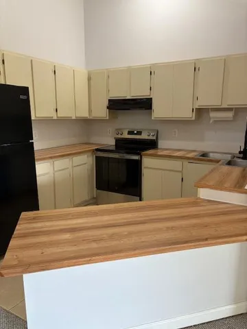 a kitchen with granite countertop white cabinets and black appliances