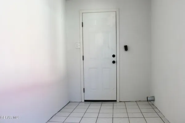 an empty room with windows and chandelier