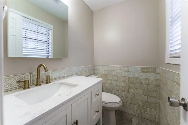 a bathroom with a sink a toilet and a mirror