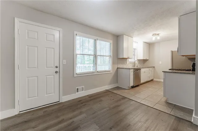 a kitchen with white cabinets and white appliances
