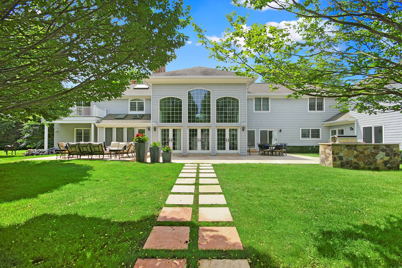 495 Ox Pasture Road Southampton, NY 11968 - Photo 1 of 28 a front view of a house with a yard
