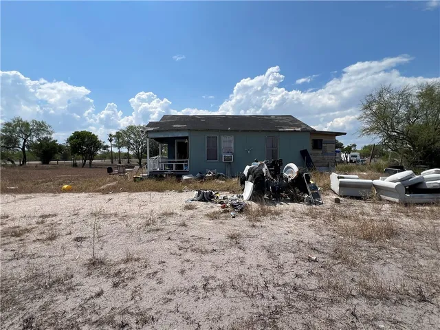 a view of a backyard with table and chairs and a barbeque