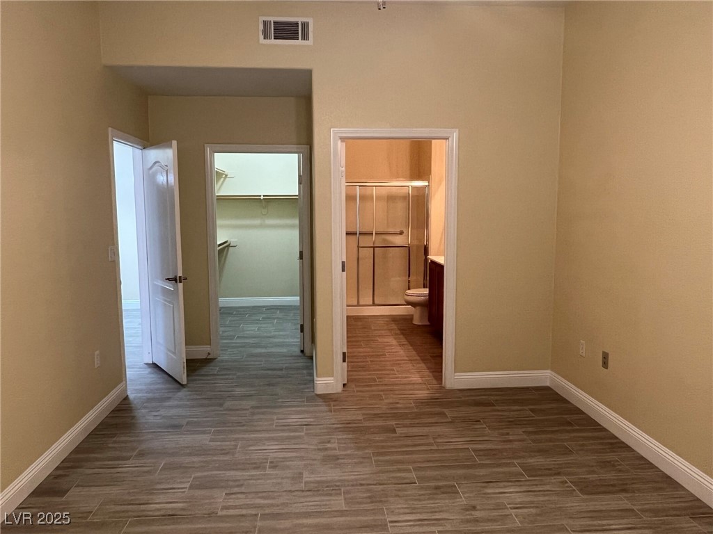 8805 Jeffreys Street, Unit 1111 Las Vegas, NV 89123 - Photo 16 of 35 Unfurnished bedroom with a walk in closet, wood tiled floors, and connected bathroom