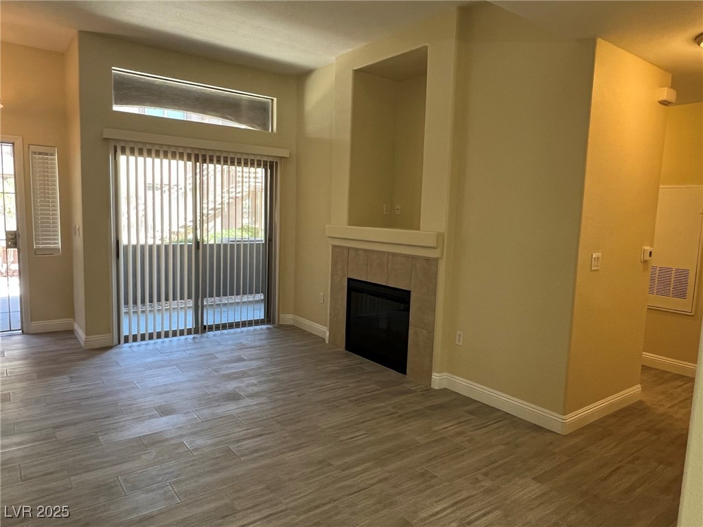 8805 Jeffreys Street, Unit 1111 Las Vegas, NV 89123 - Photo 3 of 35 Unfurnished living room featuring wood finished floors and a fireplace