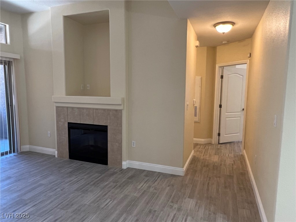 8805 Jeffreys Street, Unit 1111 Las Vegas, NV 89123 - Photo 4 of 35 Unfurnished living room featuring wood finished floors and a tiled fireplace