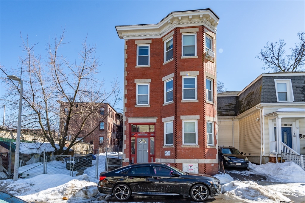 4 A Weld Avenue Boston, MA 02119 - Photo 1 of 6 a front view of a building with lot of cars parked