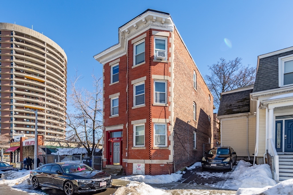 4 A Weld Avenue Boston, MA 02119 - Photo 2 of 6 a front view of a building with lot of cars and trees