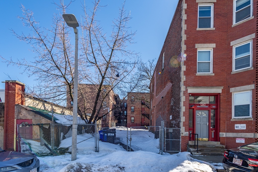 4 A Weld Avenue Boston, MA 02119 - Photo 3 of 6 a backyard of a building with multiple trees