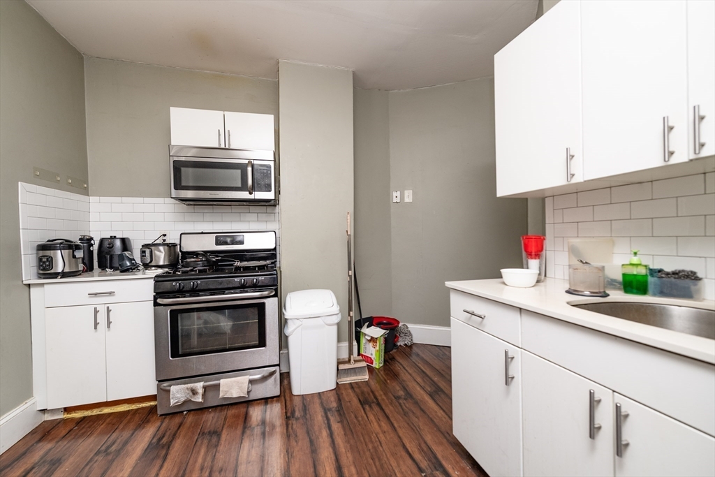 4 A Weld Avenue Boston, MA 02119 - Photo 4 of 6 a kitchen with stainless steel appliances a stove microwave and sink