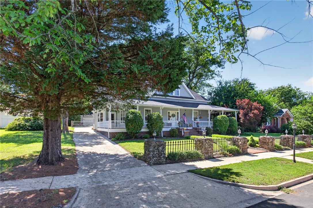 110 South Fairplay Street Seneca, SC 29678 - Photo 2 of 50 A charming residence with a wide wrap-around porch and mature trees for ample shade.