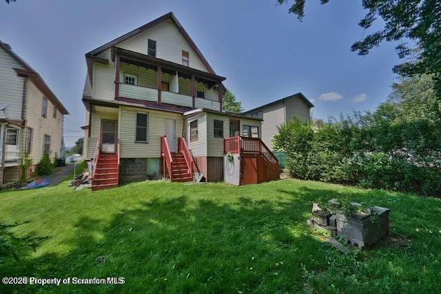 a view of a house with a yard and sitting area