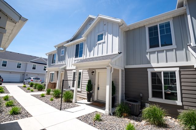 1787 North 1280 East Payson, UT 84651 - Photo 3 of 22 Two-story townhome featuring a covered entry, vertical and horizontal siding, and multiple windows with white trim