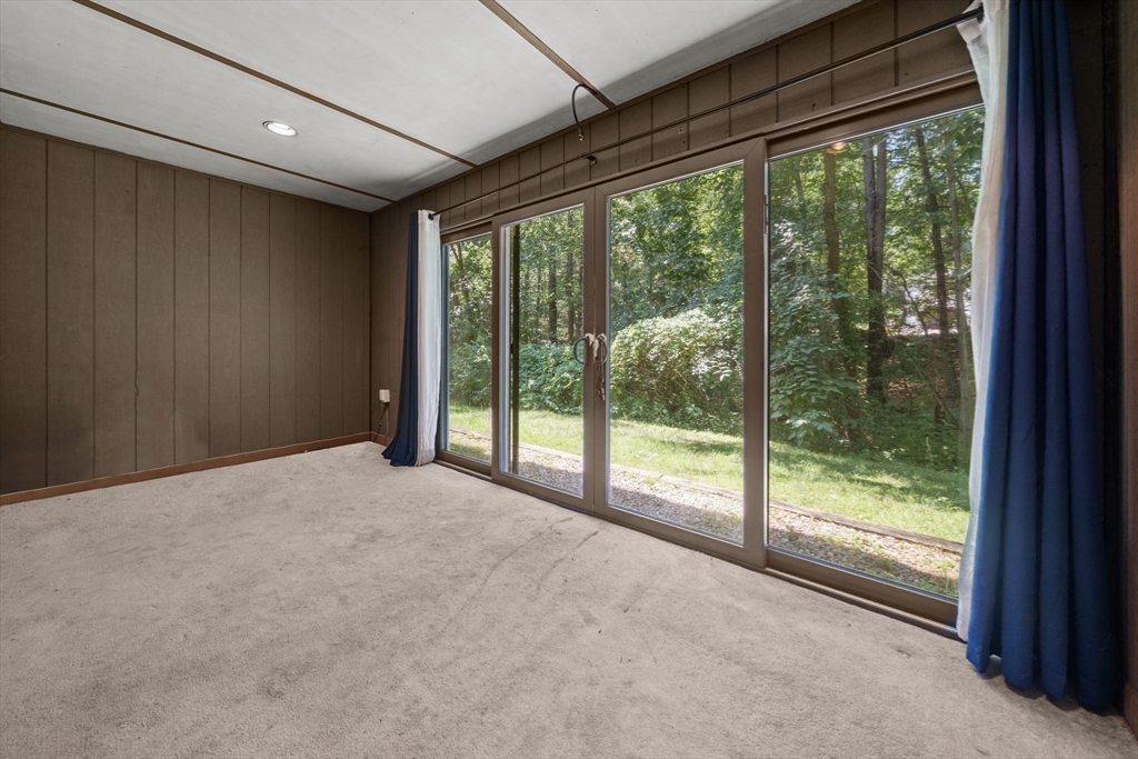 374 Great Road, Unit 11 Acton, MA 01720 - Photo 9 of 30 a view of an empty room with wooden floor and a balcony