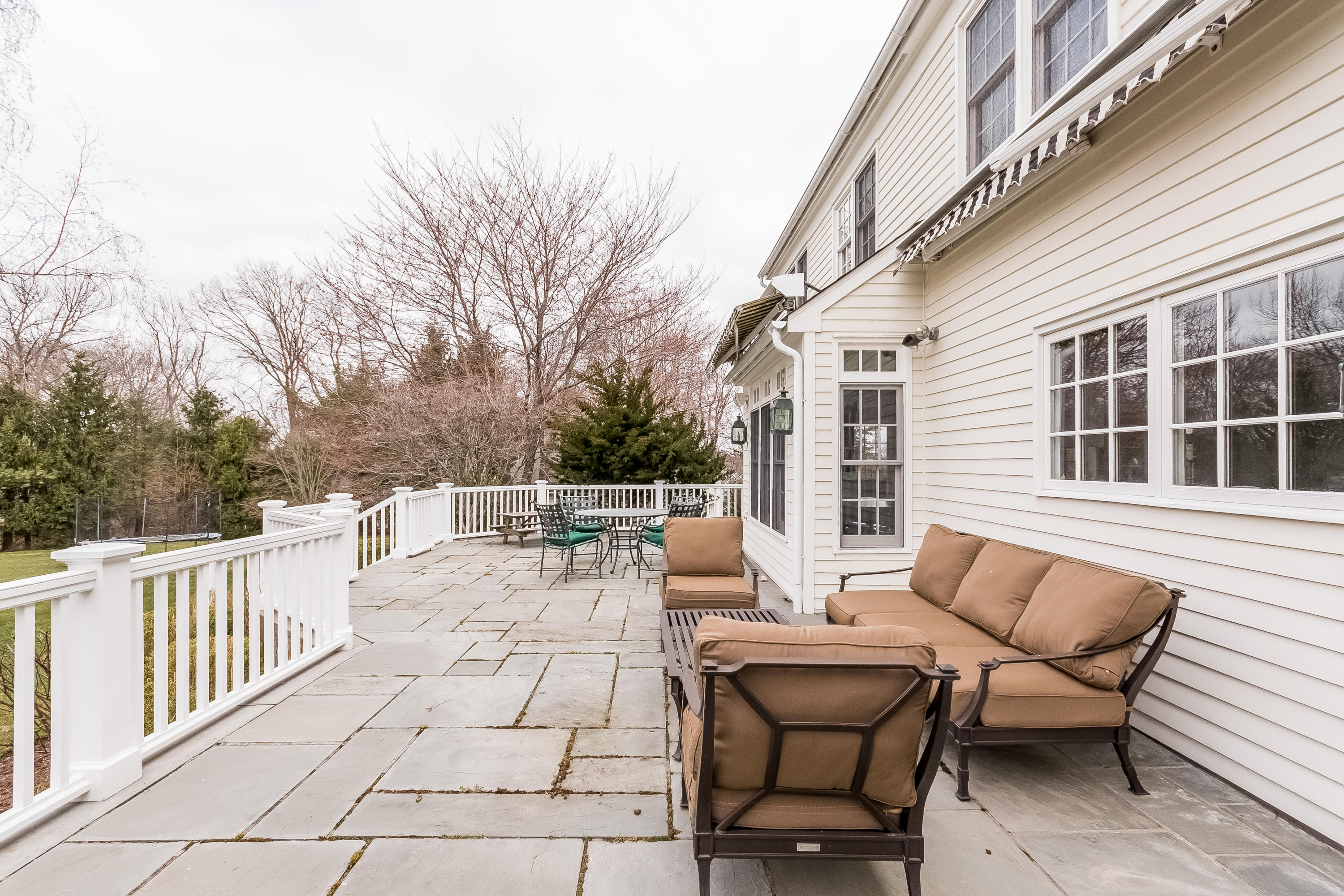 71 Peach Hill Road Darien, CT 06820 - Photo 34 of 42 a view of a patio with couches table and chairs and wooden fence