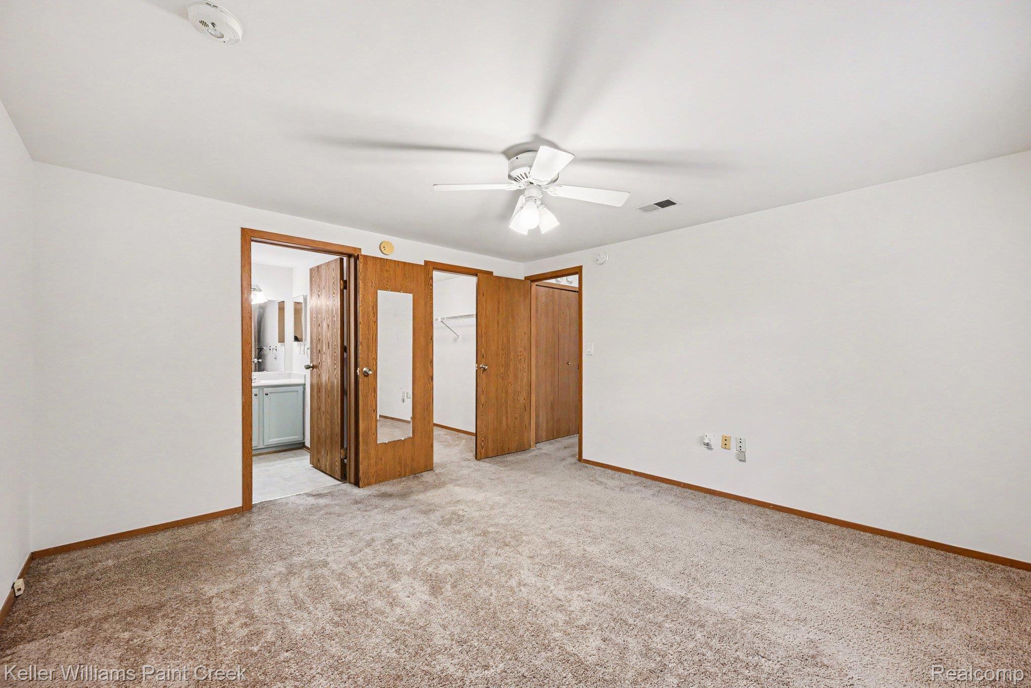 2232 London Bridge Drive Rochester, MI 48307 - Photo 18 of 26 Spacious room with neutral carpet, a ceiling fan with integrated lighting, and multiple wood-finish doors