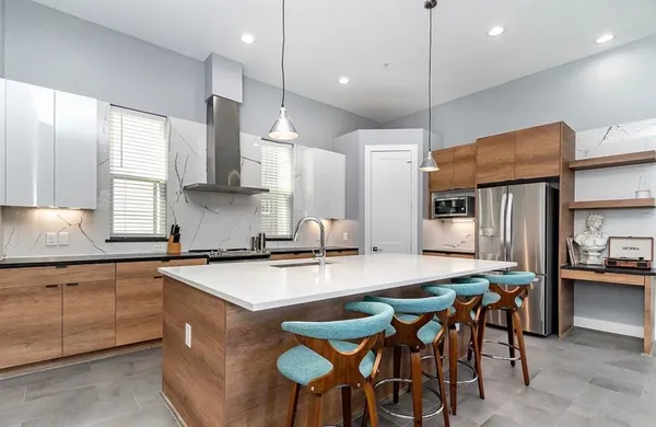 a kitchen with a stove a refrigerator a sink and chairs