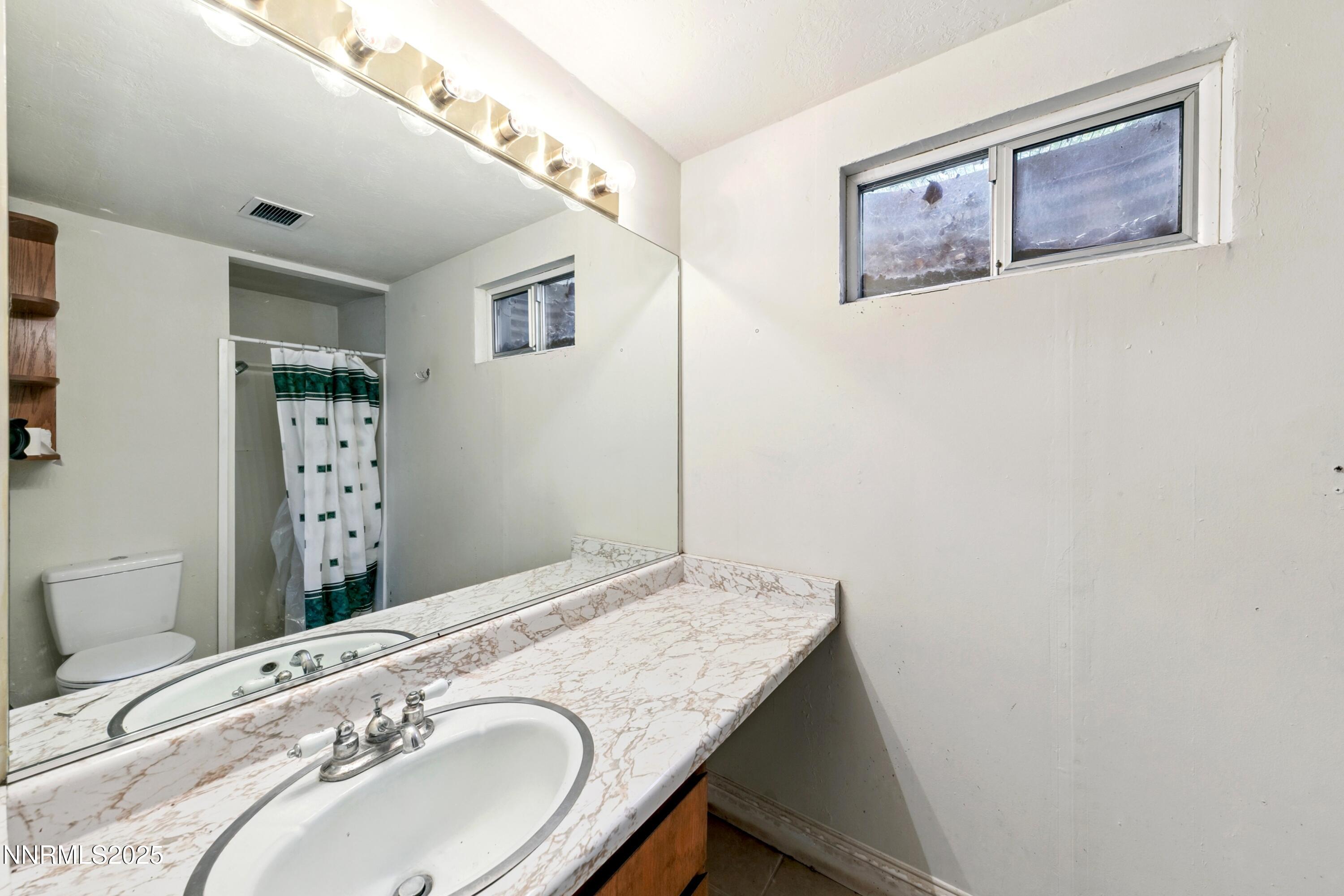 3550 Lone Tree Lane Reno, NV 89511 - Photo 36 of 40 a bathroom with a granite countertop sink and a mirror