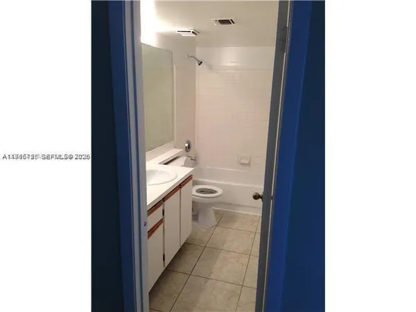 a bathroom with a granite countertop sink a toilet and a shower