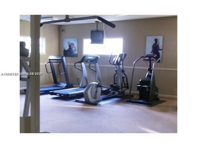 18330 Northwest 68th Avenue, Unit A Hialeah, FL 33015 - Photo 14 of 14 a room with gym equipment and wooden floor