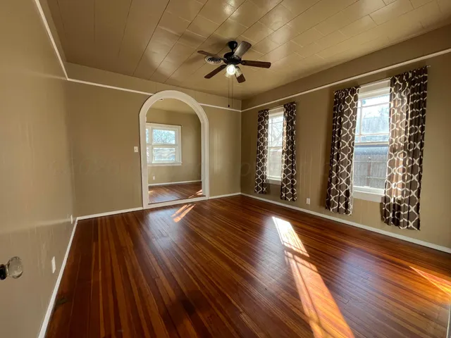 a view of empty room with window and wooden floor