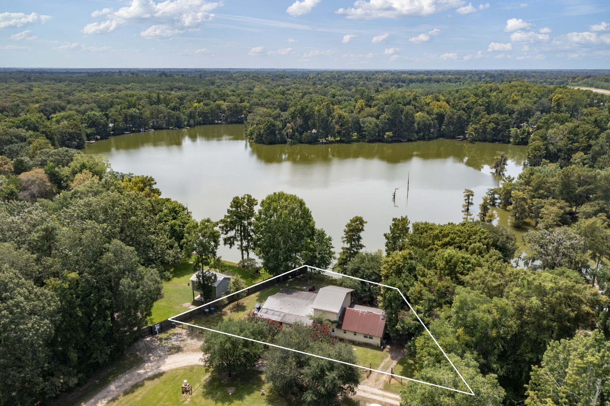 150 County Road 2122 Cleveland, TX 77327 - Photo 2 of 21 an aerial view of lake residential house with outdoor space and trees around