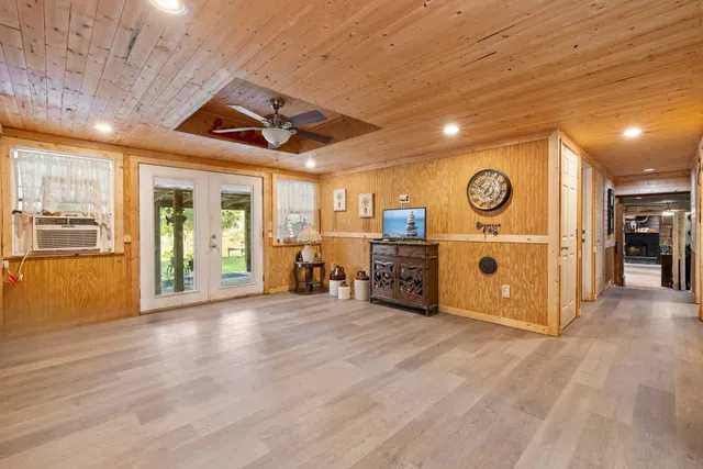 a view of an empty room with wooden floor and windows