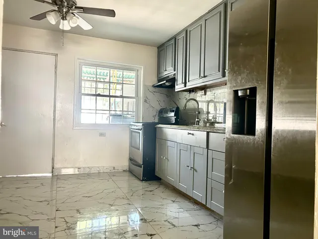 a kitchen with stainless steel appliances granite countertop white cabinets a stove a sink and dishwasher