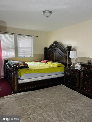a bedroom with a bed and dresser with mirror