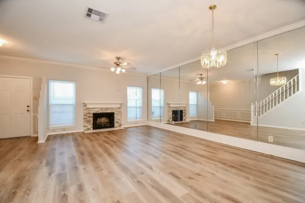a view of a livingroom with a fireplace a chandelier and wooden floor