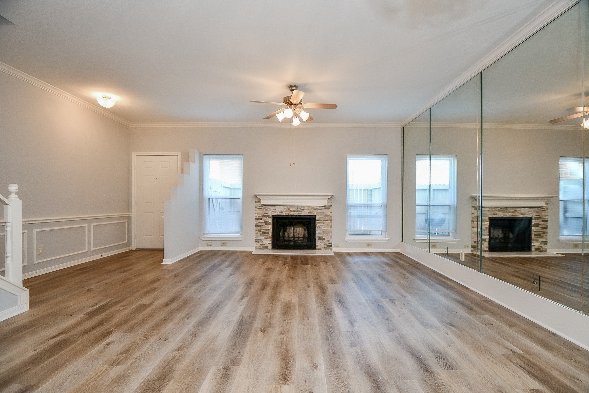 8085 El Mundo Street, Unit 8085 Houston, TX 77054 - Photo 3 of 32 an empty room with fireplace wooden floor and chandelier fan
