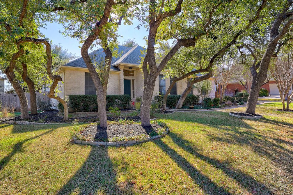 View of front of house with stone siding and a front lawn