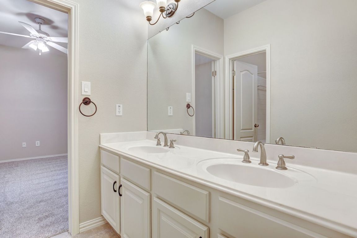301 Rim Rock Drive Georgetown, TX 78628 - Photo 27 of 40 Jack and Jill bathroom with double vanity and light carpet