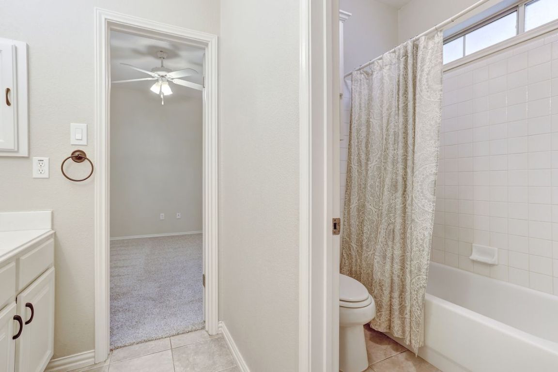 301 Rim Rock Drive Georgetown, TX 78628 - Photo 28 of 40 Bathroom with vanity, shower / bath combo, light tile patterned floors, a ceiling fan, and light carpet