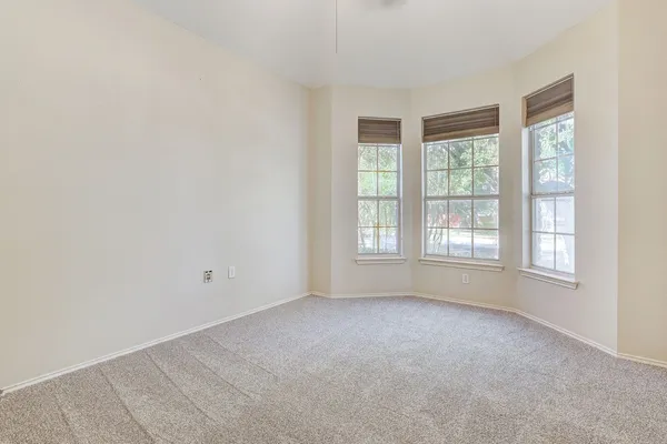 an empty room with fan and entrance