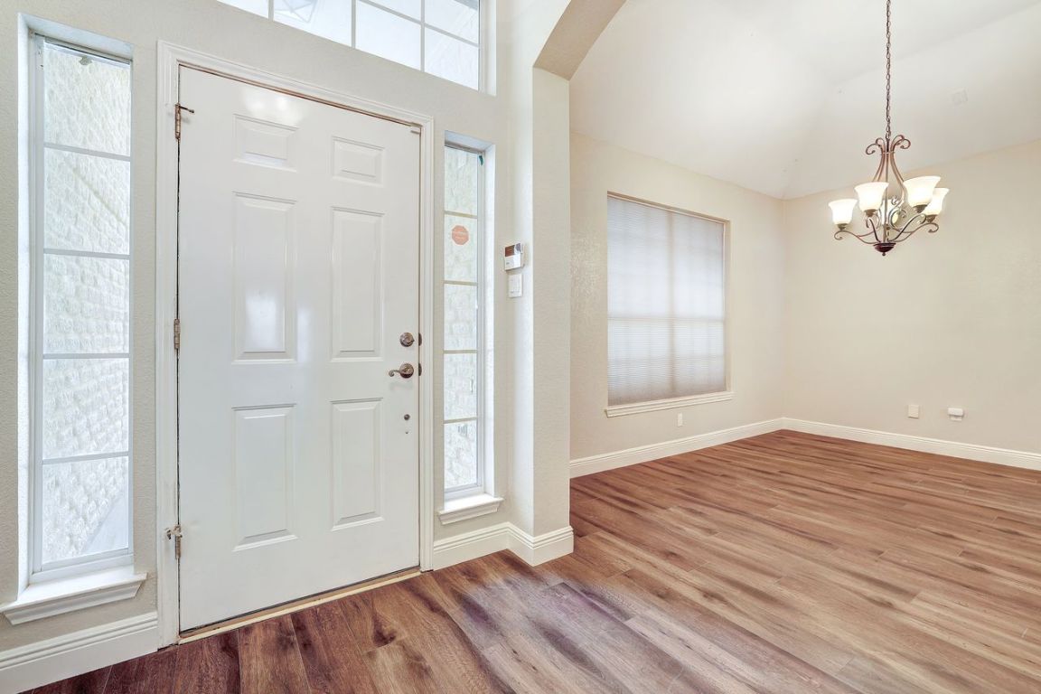 301 Rim Rock Drive Georgetown, TX 78628 - Photo 5 of 40 Foyer entrance with plenty of natural light, a chandelier, lofted ceiling, and recent vinyl plank floors