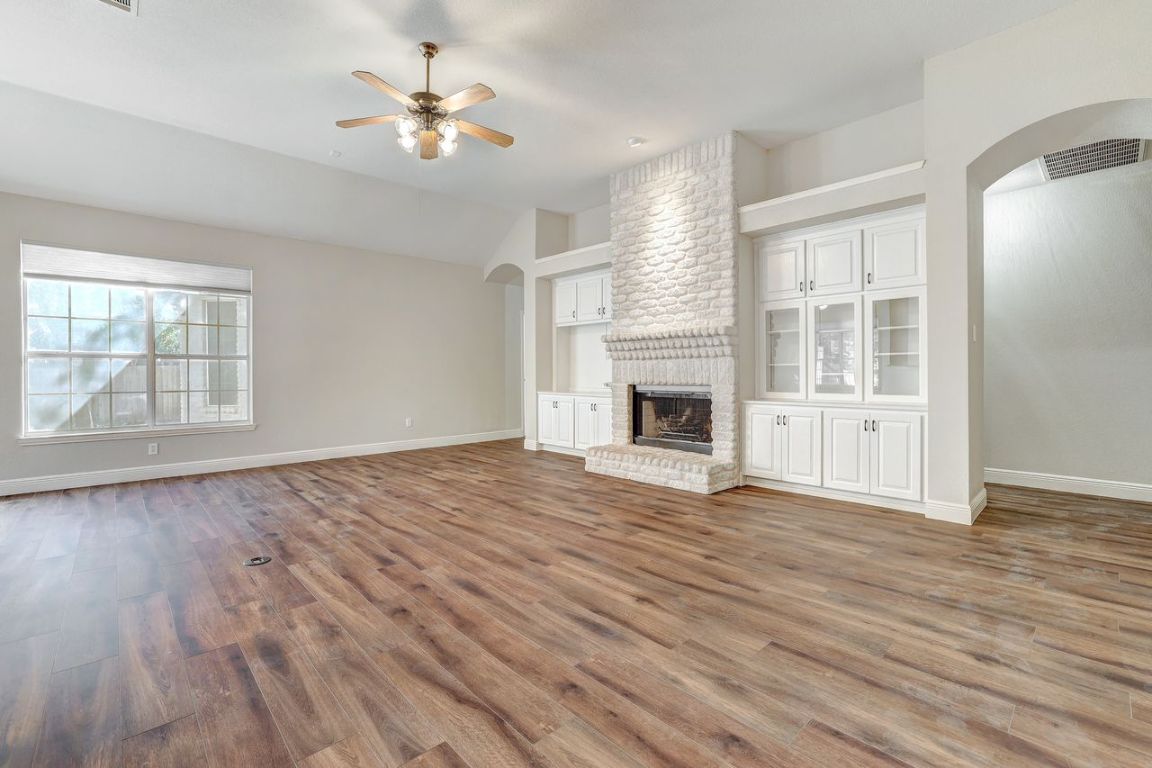 301 Rim Rock Drive Georgetown, TX 78628 - Photo 9 of 40 Huge living room featuring arched walkways, a stone fireplace, light wood-style floors, lofted ceiling, and a ceiling fan