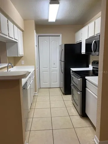 a kitchen with stainless steel appliances granite countertop a refrigerator and a stove