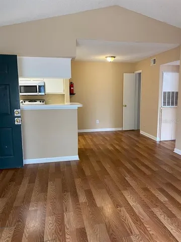a view of a kitchen with wooden floor and a sink