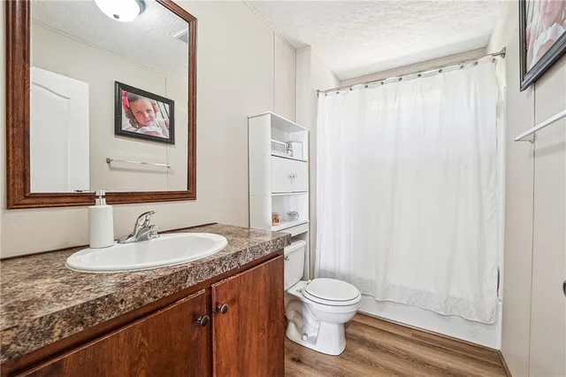 a bathroom with a granite countertop sink toilet and shower