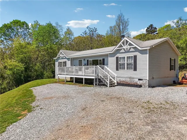 a view of a house with a yard and potted plants