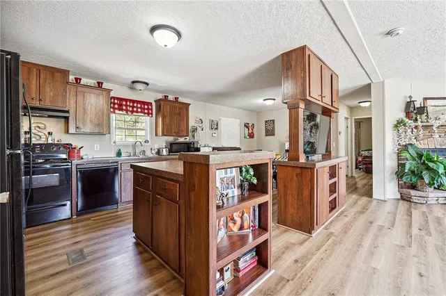 a kitchen with stainless steel appliances granite countertop a stove a sink dishwasher and a refrigerator