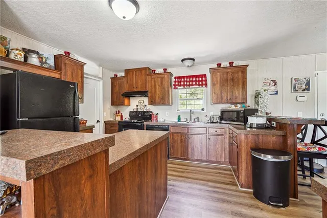a kitchen with stainless steel appliances granite countertop a sink a stove a refrigerator and a refrigerator