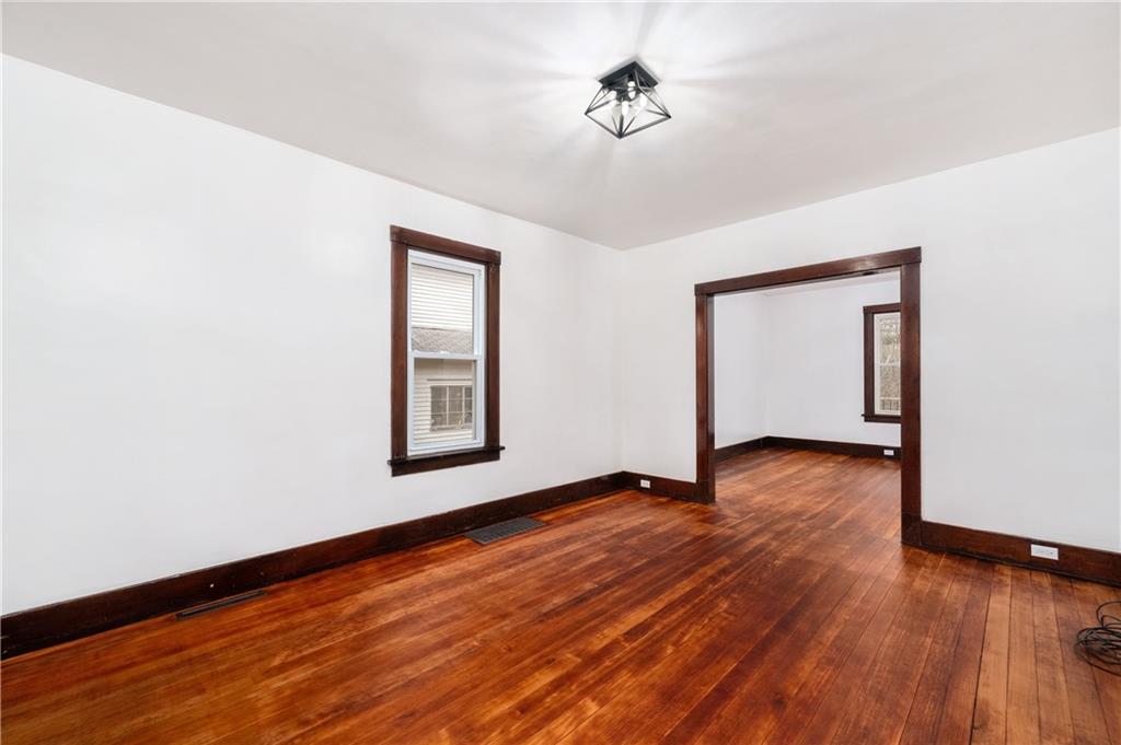 140 Whitestown Road Lyndora, PA 16045 - Photo 6 of 29 a view of an empty room with wooden floor and a window